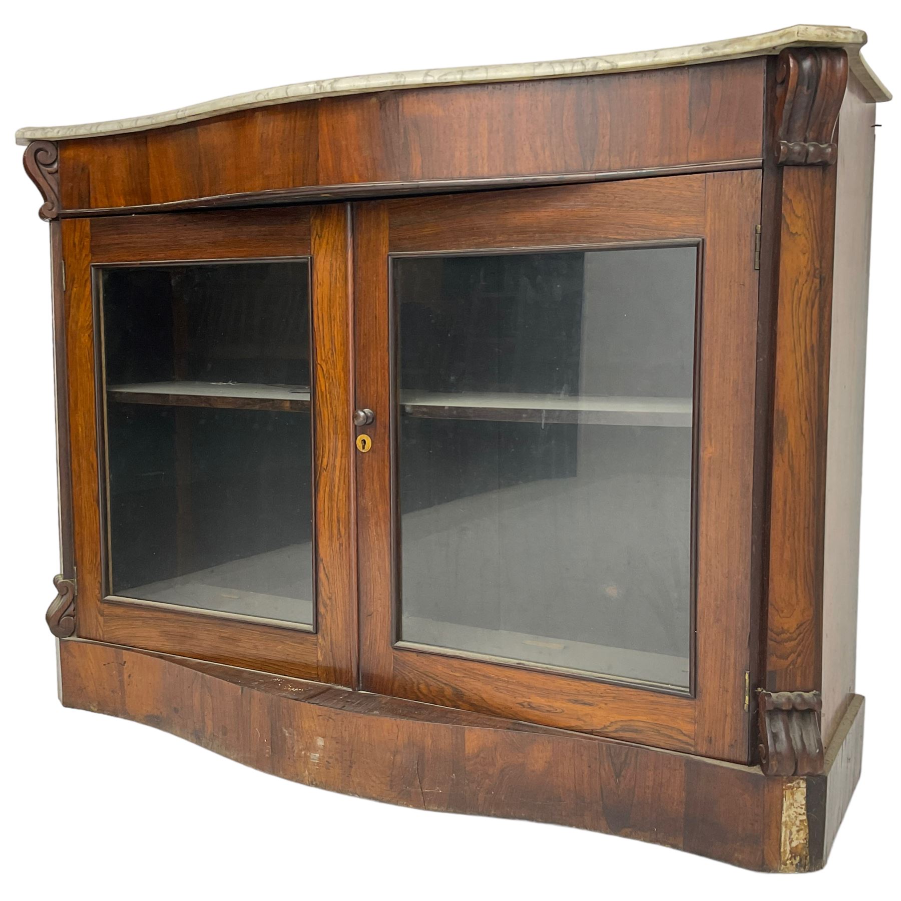 Victorian rosewood side cabinet, shaped and moulded white marble top over plain frieze, single shelf enclosed by two glazed doors, flanked by square pilasters with S-scroll carved brackets, on plinth base