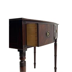 George III mahogany kneehole dressing or writing table, stepped bow-front form, reed moulded top with mahogany crossband, fitted with three cock-beaded drawers with circular pressed brass handle plates decorated with urn and beaded ring handle, on ring turned supports 