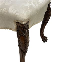 Georgian Irish mahogany dressing stool, overstuffed seat upholstered in in ivory damask fabric, the cabriole supports decorated with moulded interlacing scroll motifs with mycelium cap detail, over lobe carvings terminating to large paw feet