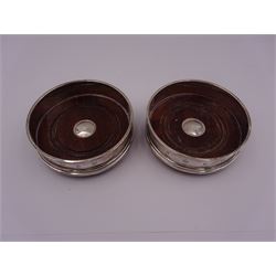 Pair of modern silver mounted bottle coasters, each with a turned mahogany centre, hallmarked Carr's of Sheffield, Sheffield 2003 & 2005, D10cm