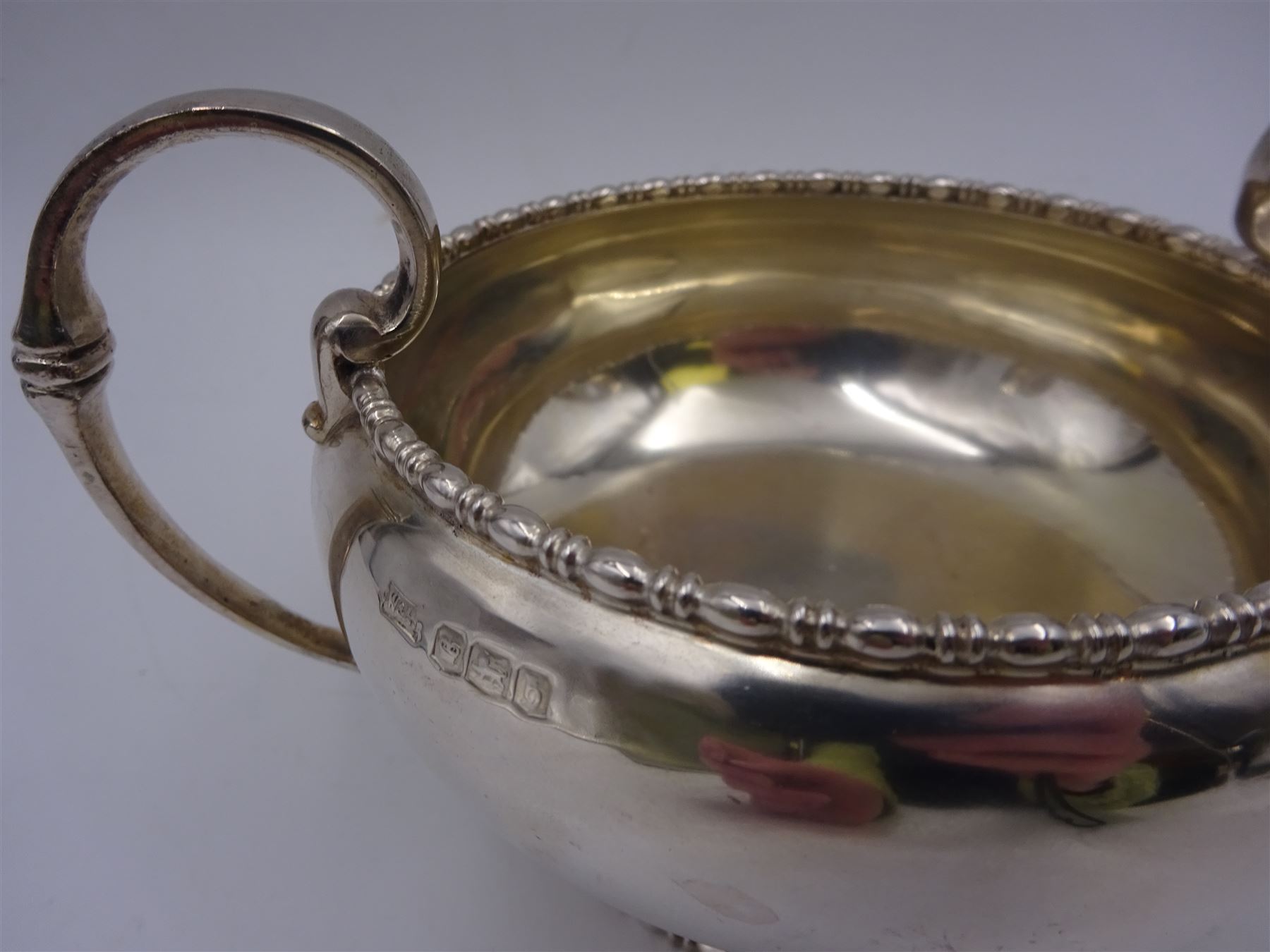 Early 20th century silver twin handled bowl, of plain bellied form with bead and dart rim and two C scroll handles, upon a circular foot, hallmarked Walker & Hall, Sheffield 1919, including handles H9.5cm