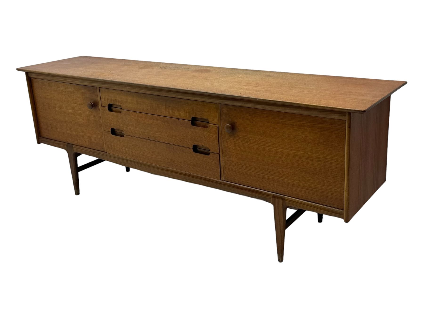 Younger - mid-20th century teak sideboard, rectangular top over three central drawers with recessed handles, flanked by two cupboard doors enclosing two shelves, on tapered supports joined by stretchers