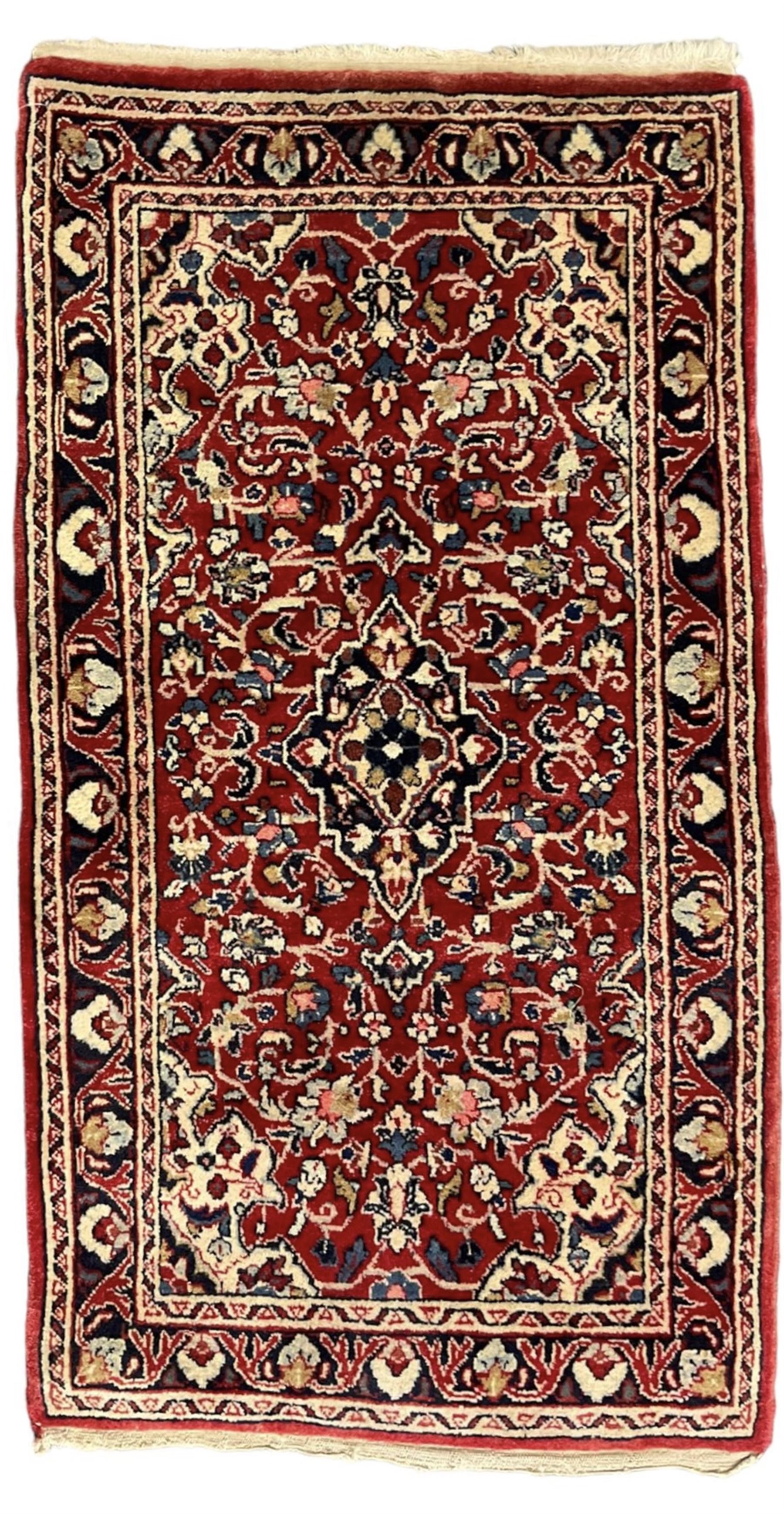 Persian crimson ground rug or mat, field decorated with central medallion and all-over scrolling floral motifs, border with repeating palmettes