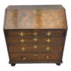 George I figured walnut bureau, hinged fall front enclosing drawers, pigeon holes and slide revealing storage well, fitted with four long cock-beaded and graduating drawers, shaped brass handle plates and escutcheons, on turned bun feet 