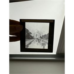 Collection of magic lantern slides, predominantly depicting views of India, with scenes including including the Taj Mahal, tombs, monuments, street scenes, people and animals, in compartmentalised wooden case 