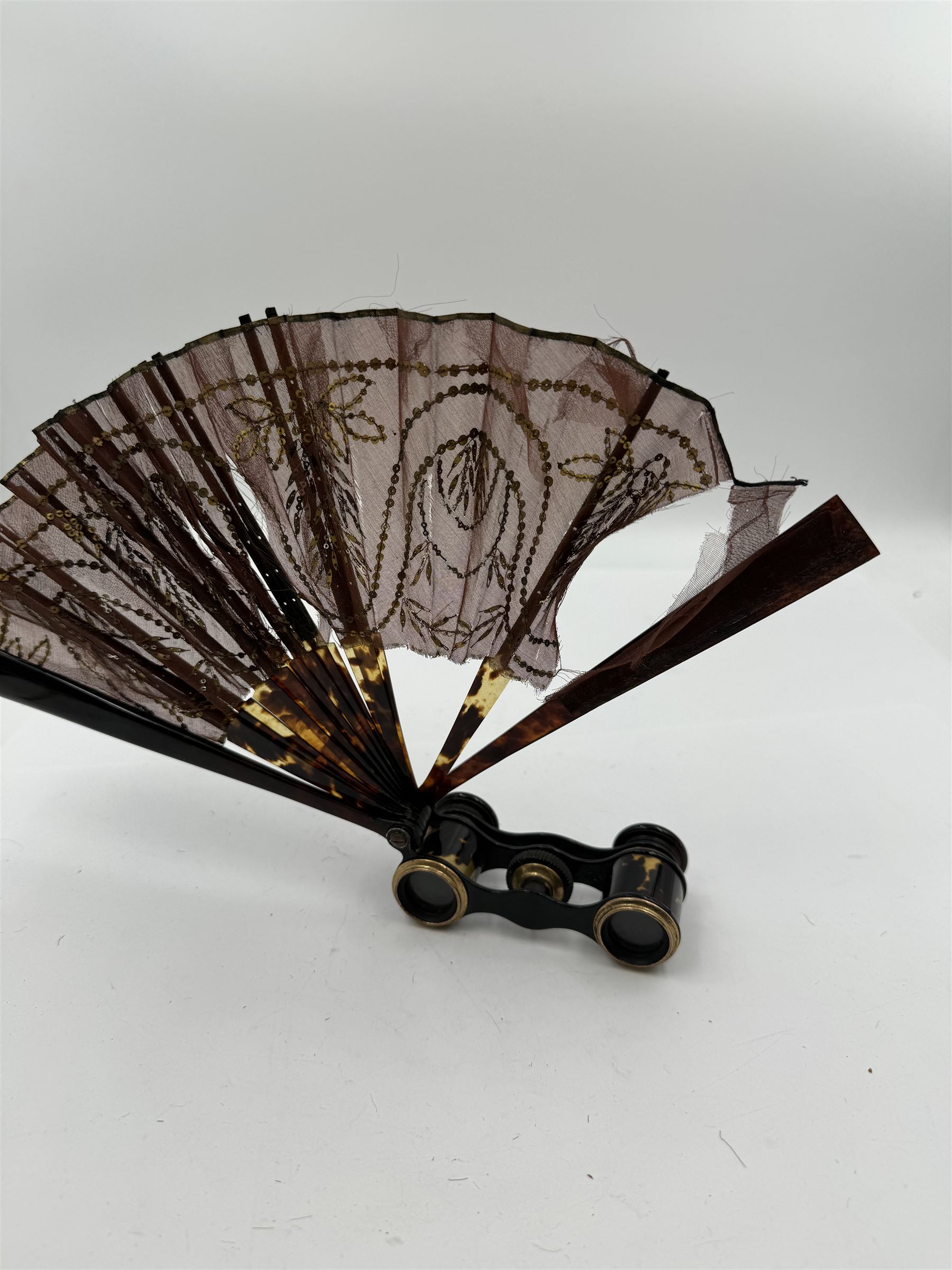 Early 20th century Asprey & Co opera glasses, with simulated tortoiseshell body and handle, the handle opening to reveal a chiffon fan, finely worked with sequins, stamped Asprey & Co London