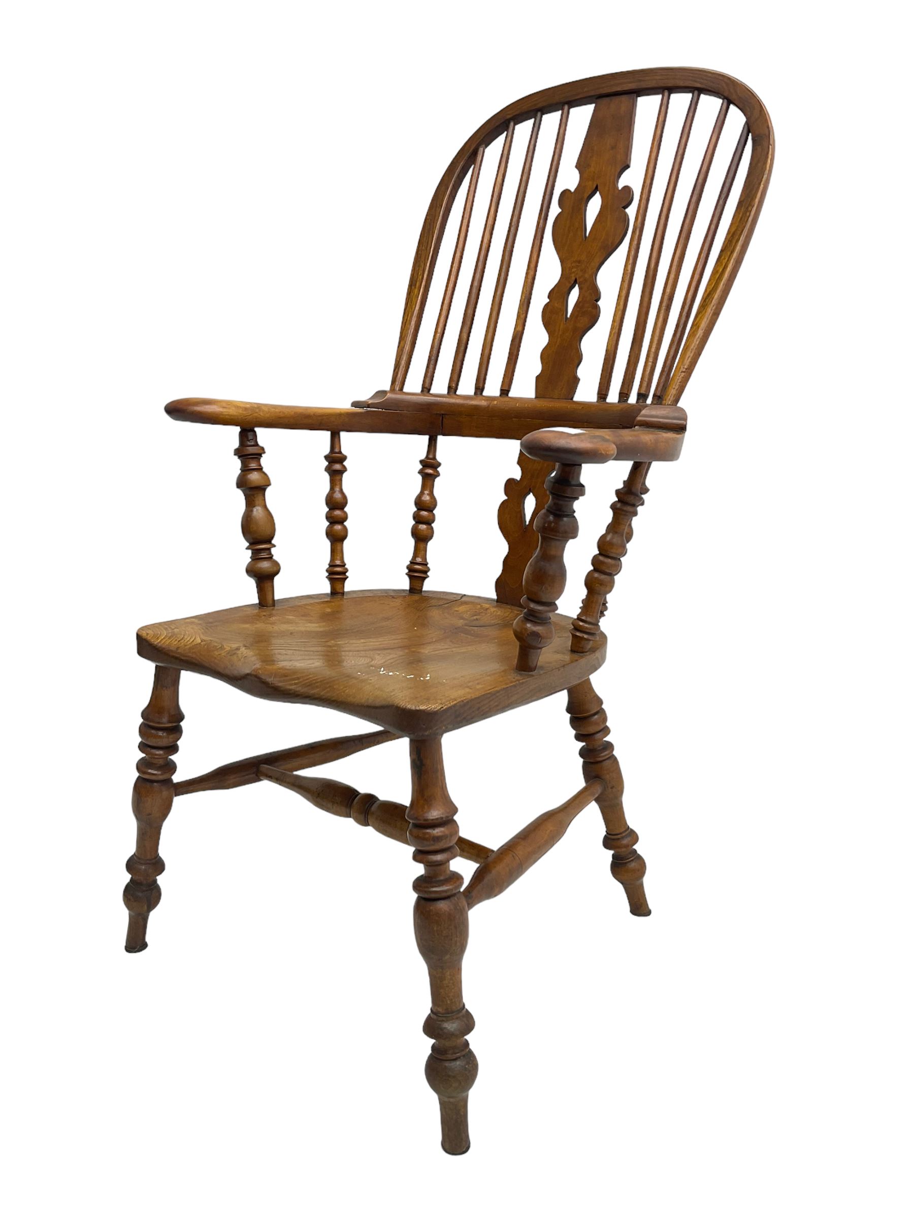 Elm and beech high back Windsor chair,  high hoop back with pierced splat and spindle supports over shaped saddle seat, raised on ring turned supports united by H-stretcher