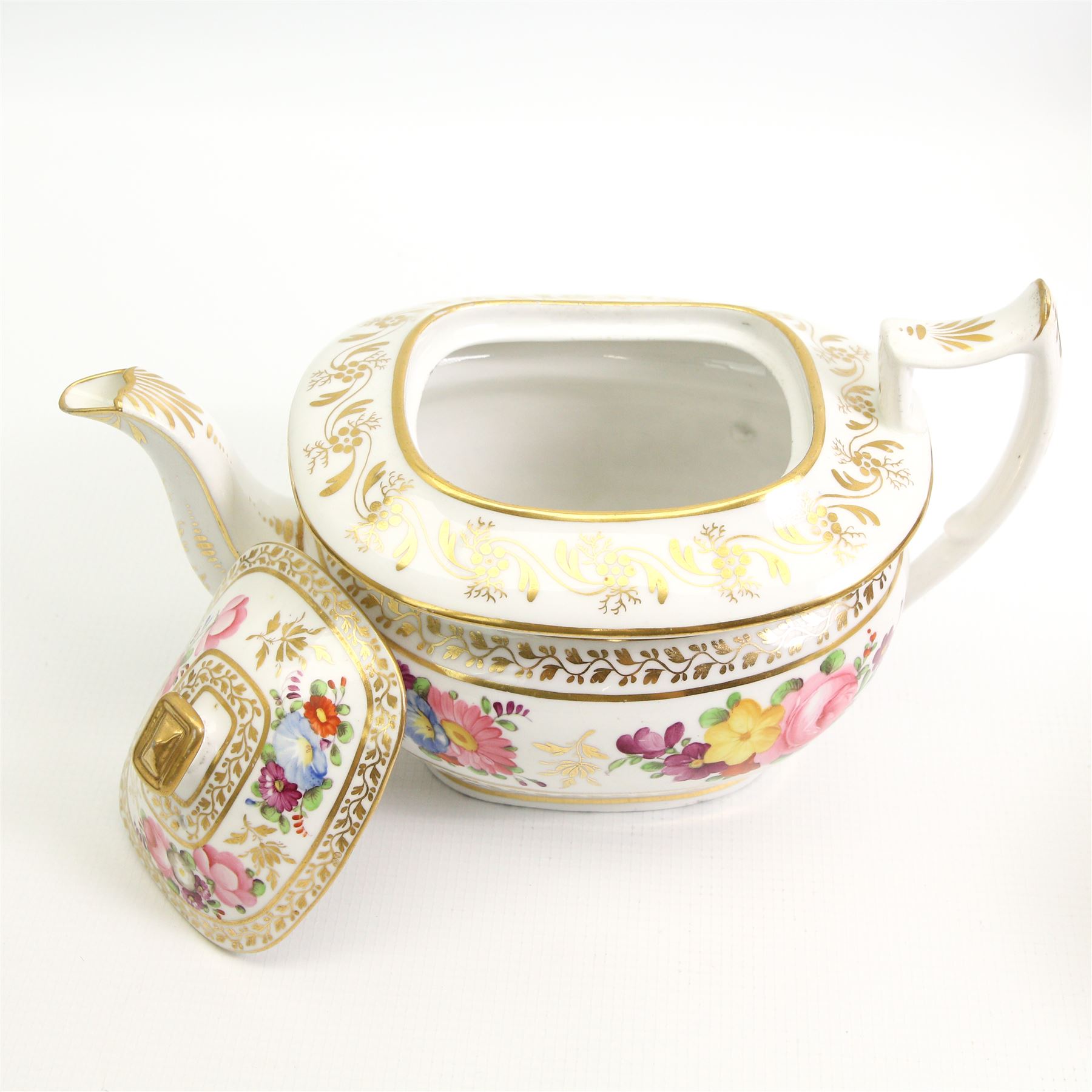 Early 19th century English porcelain tea service, hand painted with floral sprays within trailing gilt borders, comprising teapot and stand, slop bowl, sucrier, milk jug and eight saucers 