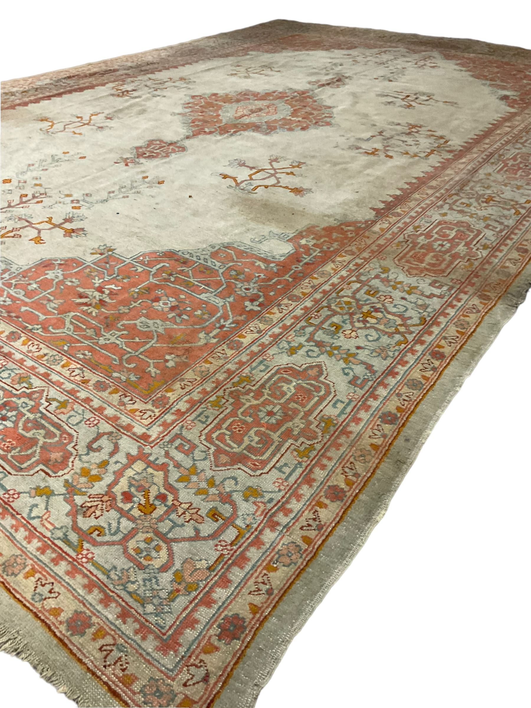 Large Persian pale sage ground carpet, the field decorated with central geometric medallion and tree of life motifs, the border with repeating geometric design decorated with stylised plant motifs