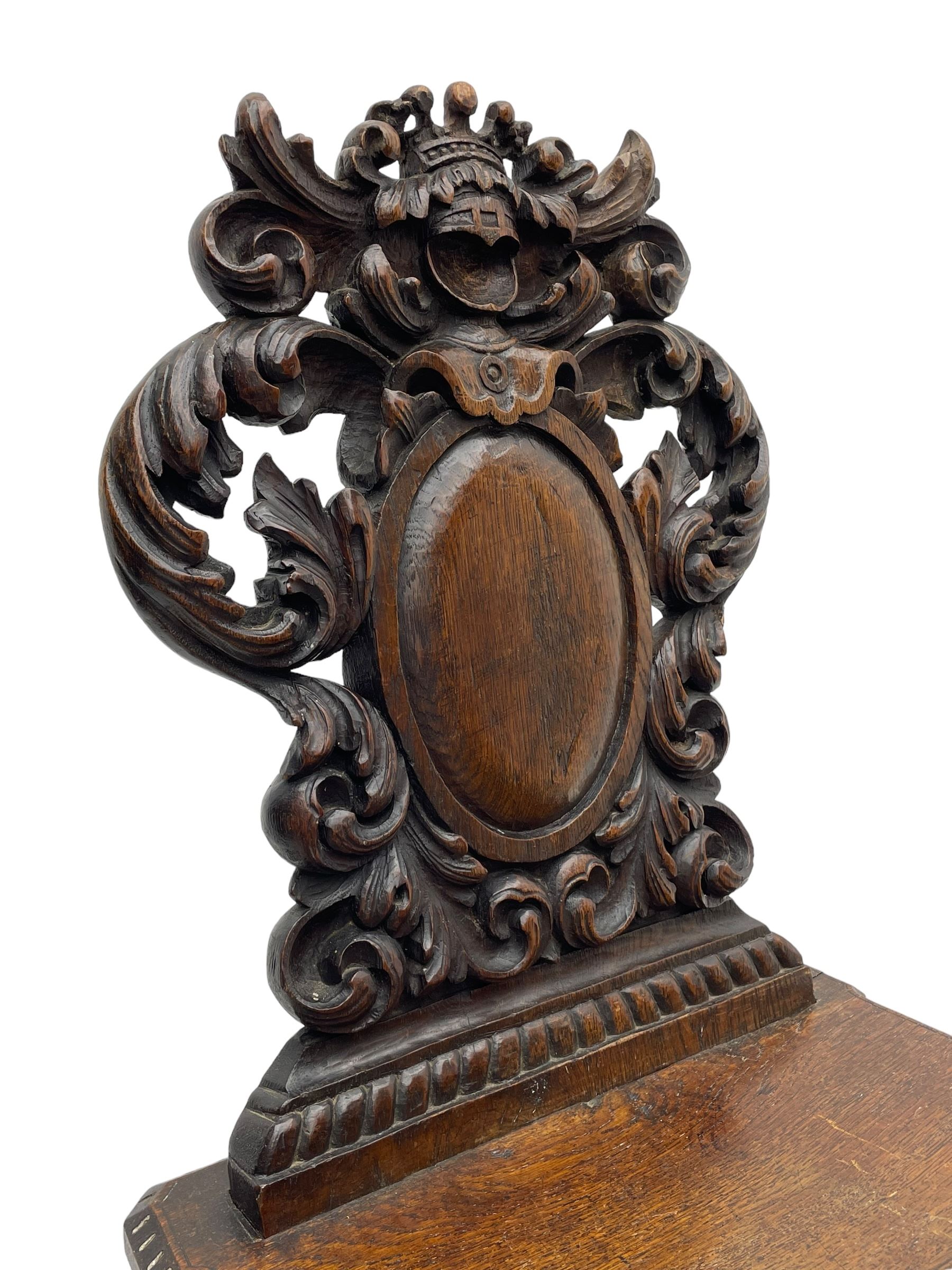 19th century oak hall chair, shaped and pierced back carved with crown cresting over curled and scrolled acanthus leaves, tapered rectangular seat with foliate carved corners and fluted chamfered edge, on turned and lobe carved splayed supports 