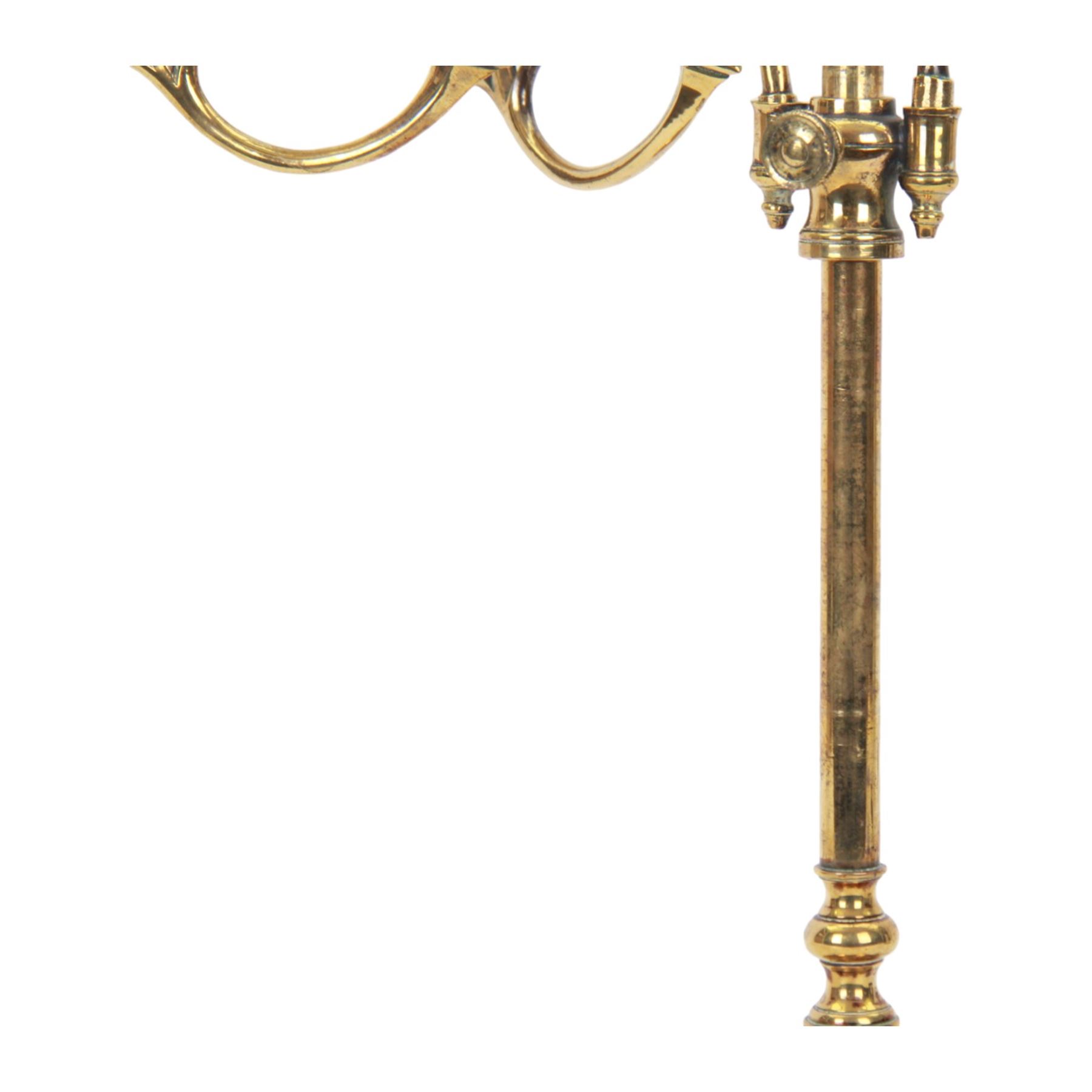 19th century brass adjustable candlestick, the spreading circular base leading to a basal knopped stem supporting adjustable twin scroll arms with urn shaped sockets above circular drip pans, H38cm W43.5cm