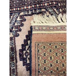 Persian peach ground rug, the field divided into four panels each with geometric lozenge, multiple band border with stylised flower head motifs, the end panels decorated with repeating lozenges