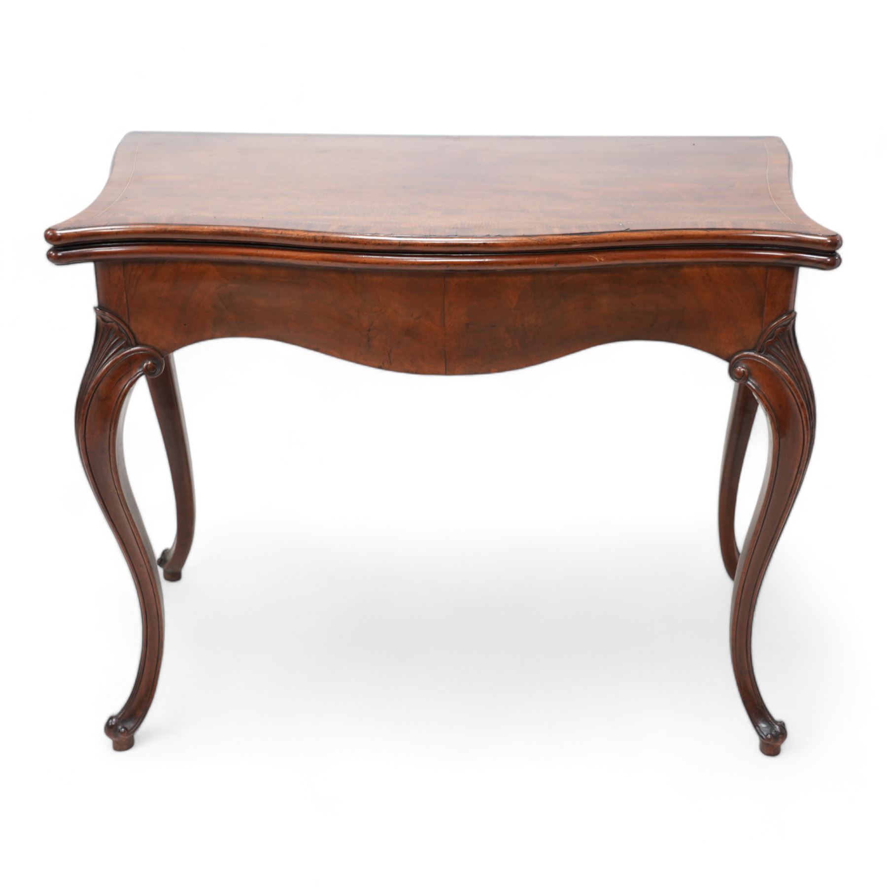 George III inlaid mahogany card table of serpentine form, the shaped rectangular fold-over top decorated with cross-banding and chequered inlay, opening to reveal a baize lined interior, the shaped apron over moulded cabriole supports with scroll and scallop carved knees, on scroll feet