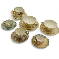 Three Pirkenhammer cups and saucers, two decorated with gilt birds in foliage on an ivory ...