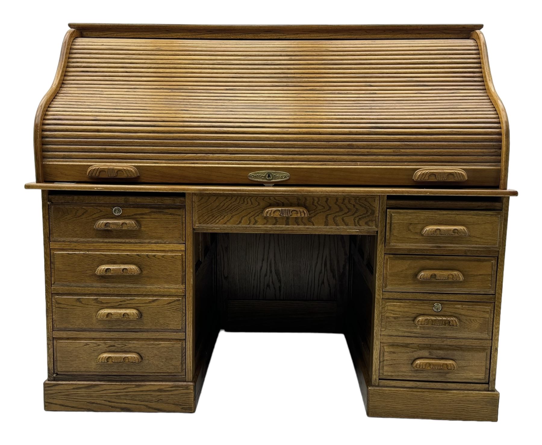 Early 20th century oak tambour roll-top desk, the top with fitted interior including drawers, pigeonholes and compartments, the twin pedestals fitted with four drawers with carved handles, supported by plinth base 