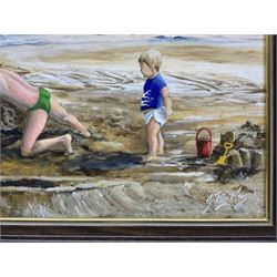 Glenys Bintley (Northern British 20th Century): Children Building a Sandcastle, oil on board signed, artists address label verso 34cm x 64cm