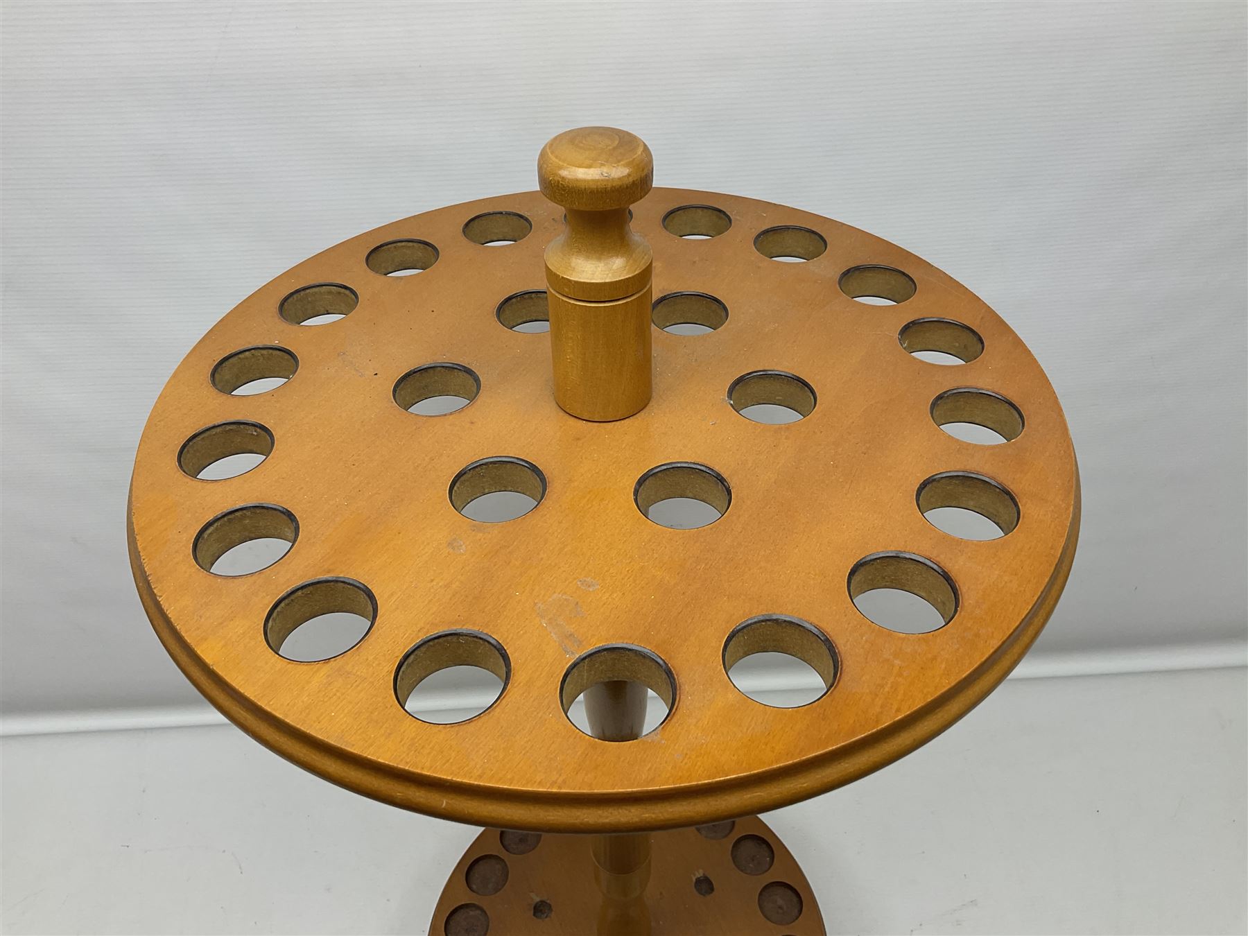 Pine stick stand, with turned central column dividing two circular tiers, upon three feet, with capacity for twenty four walking sticks, H73cm