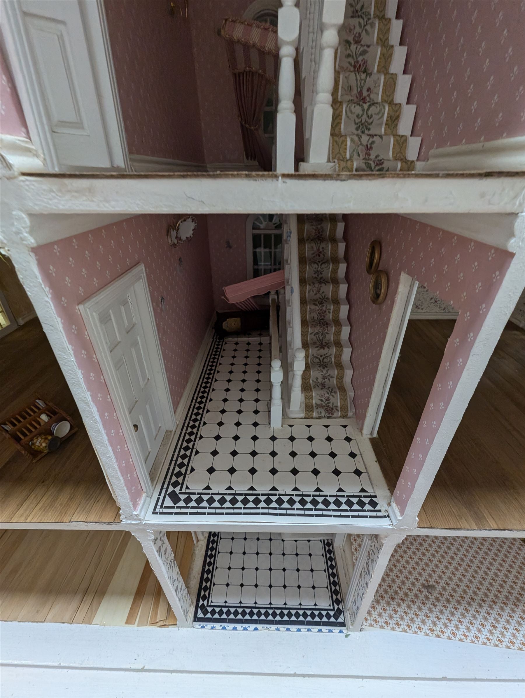 Large three storey modern dolls house, painted white with latticed windows, grey roof and metal fencing, with decorated interior, together with two dolls house garden rooms and two conservatories