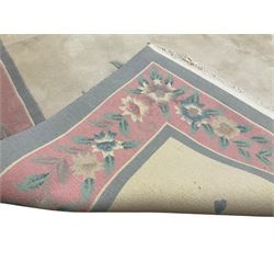 Chinese ivory ground washed woollen carpet, the field decorated with five large floral motifs with extending leafage, the wide rose guard band decorated with further floral patterns