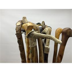 Oak barley twist stick stand, with a collection of walking sticks including examples with carved pommels, horn handles, silver collar etc, together with brass stick stand 