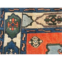 Turkish indigo ground rug, the shaped central field decorated with a central geometric stylised plant motif, enclosed with a guarded border decorated with contrasting motifs 