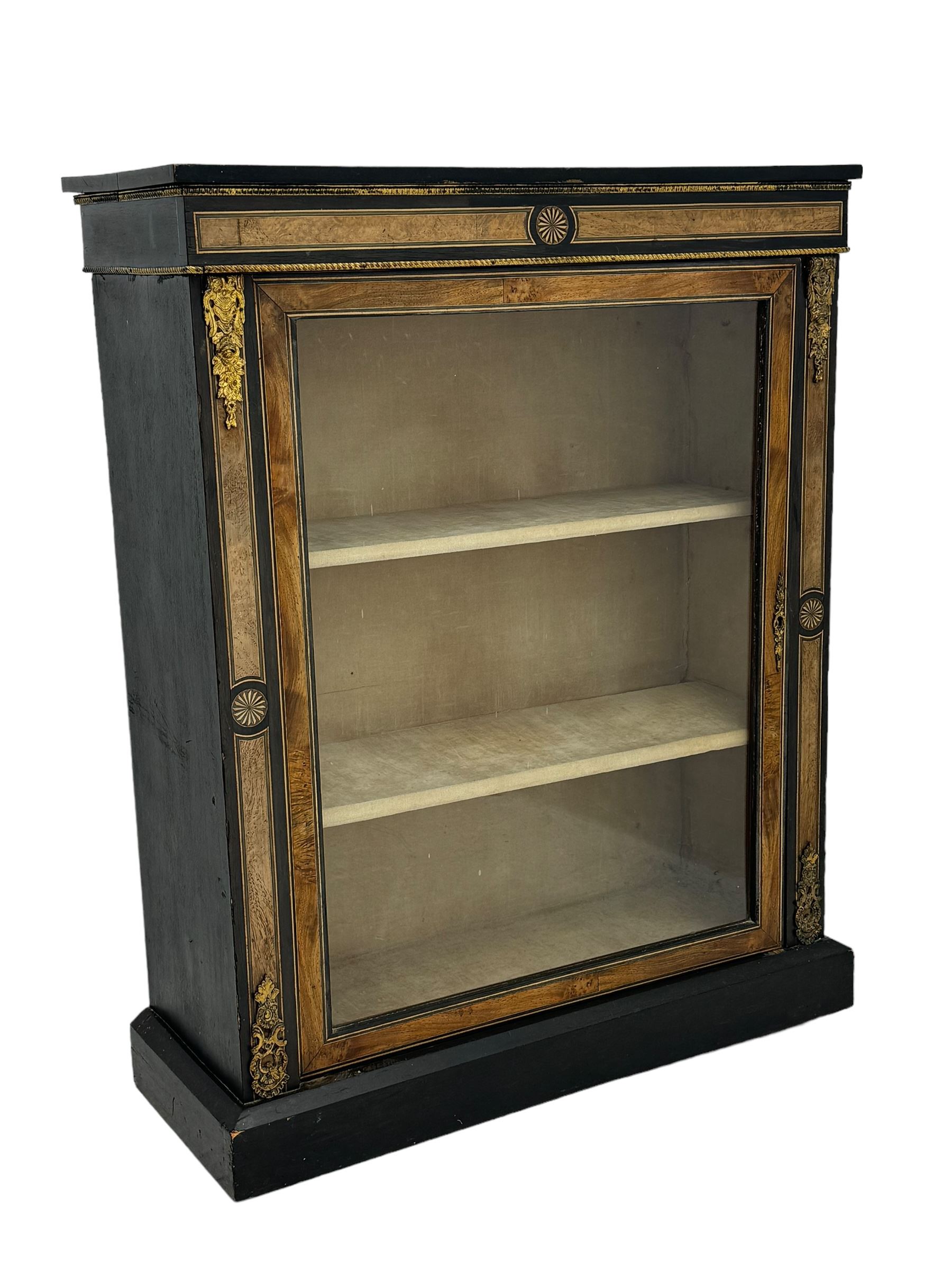 Victorian ebonised and walnut pier cabinet, rectangular top over figured frieze with central star motifs, enclosed by single glazed door, decorated with cast gilt metal mounts and beading, on chamfered plinth base 