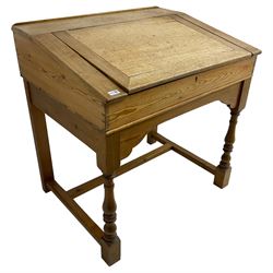 Early 20th century pitch pine clerk’s desk, stripped mahogany sloped hinged top, raised on turned supports