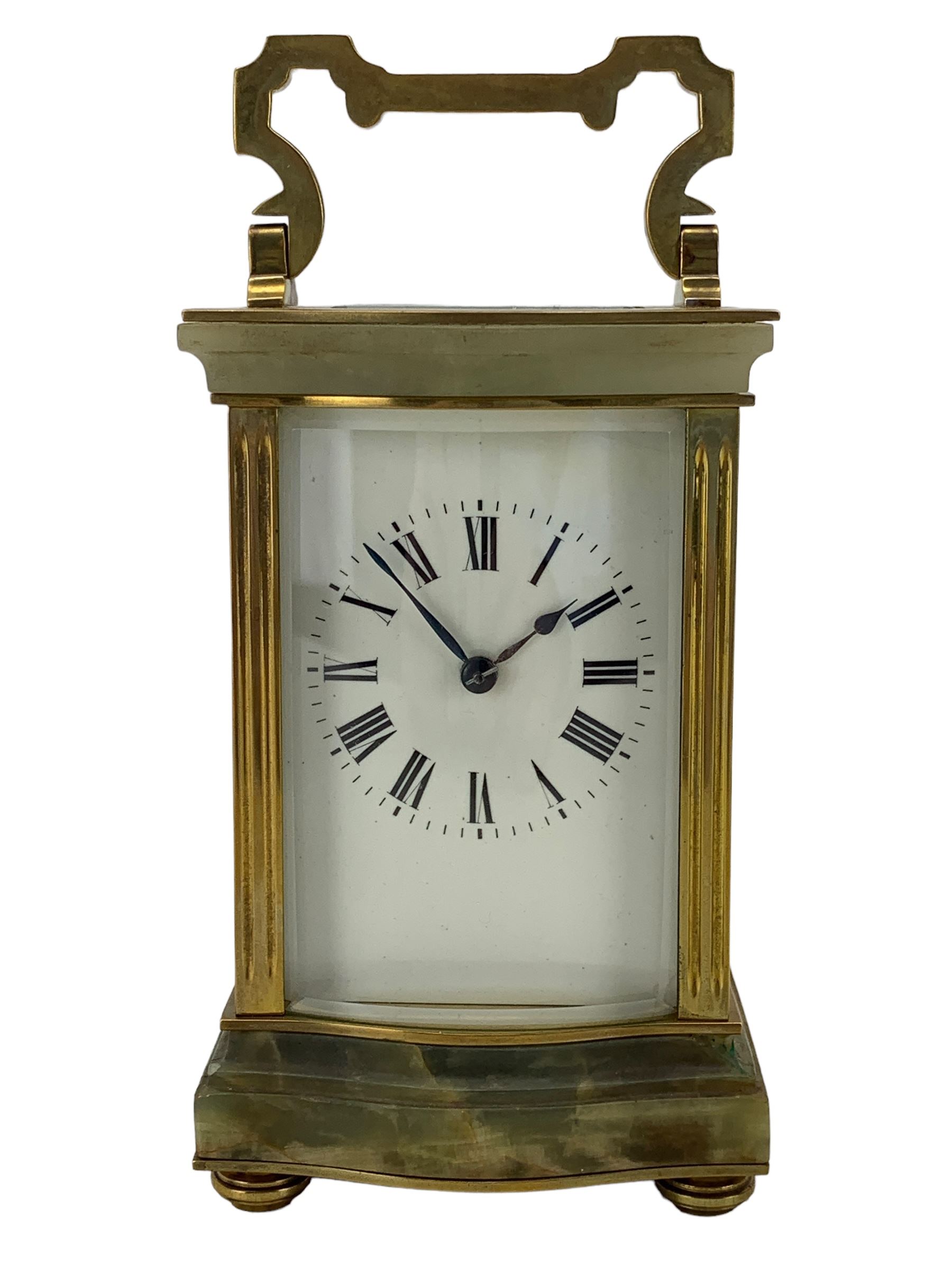 French - early 20th century two train carriage clock, in an onyx serpentine case raised on bun feet, with four bevelled panels and rectangular escapement viewing panel, white enamel dial with Roman numerals and steel spade hands, 8-day movement with a jewelled lever platform escapement and rack striking, sounding the hours and half hours on a coiled gong. With key.