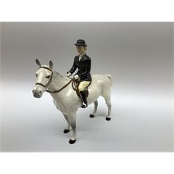 Beswick Hunting Group, comprising: two huntswoman on grey horses, model no 1730, huntsman on a bay horse, model no 1501, a seated fox, model no 1748, eighteen fox hounds and a spaniel, model no 967, all with printed marks beneath, together with three other ceramic huntsman on horseback and two hounds. 