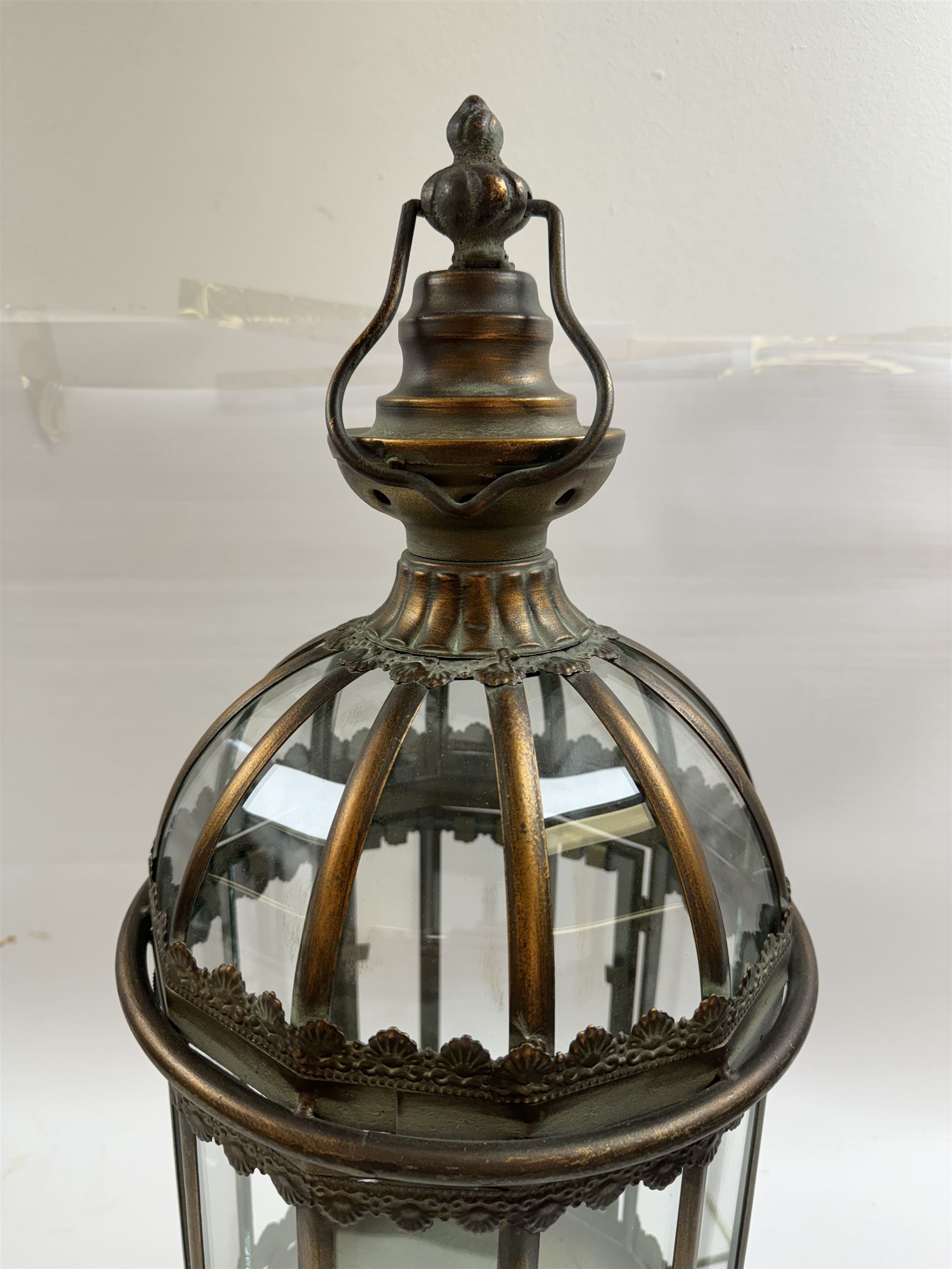 Pair of patinated brushed brass lanterns, of domed hexagonal form, with pierced gallery and swing handle, H63cm 


