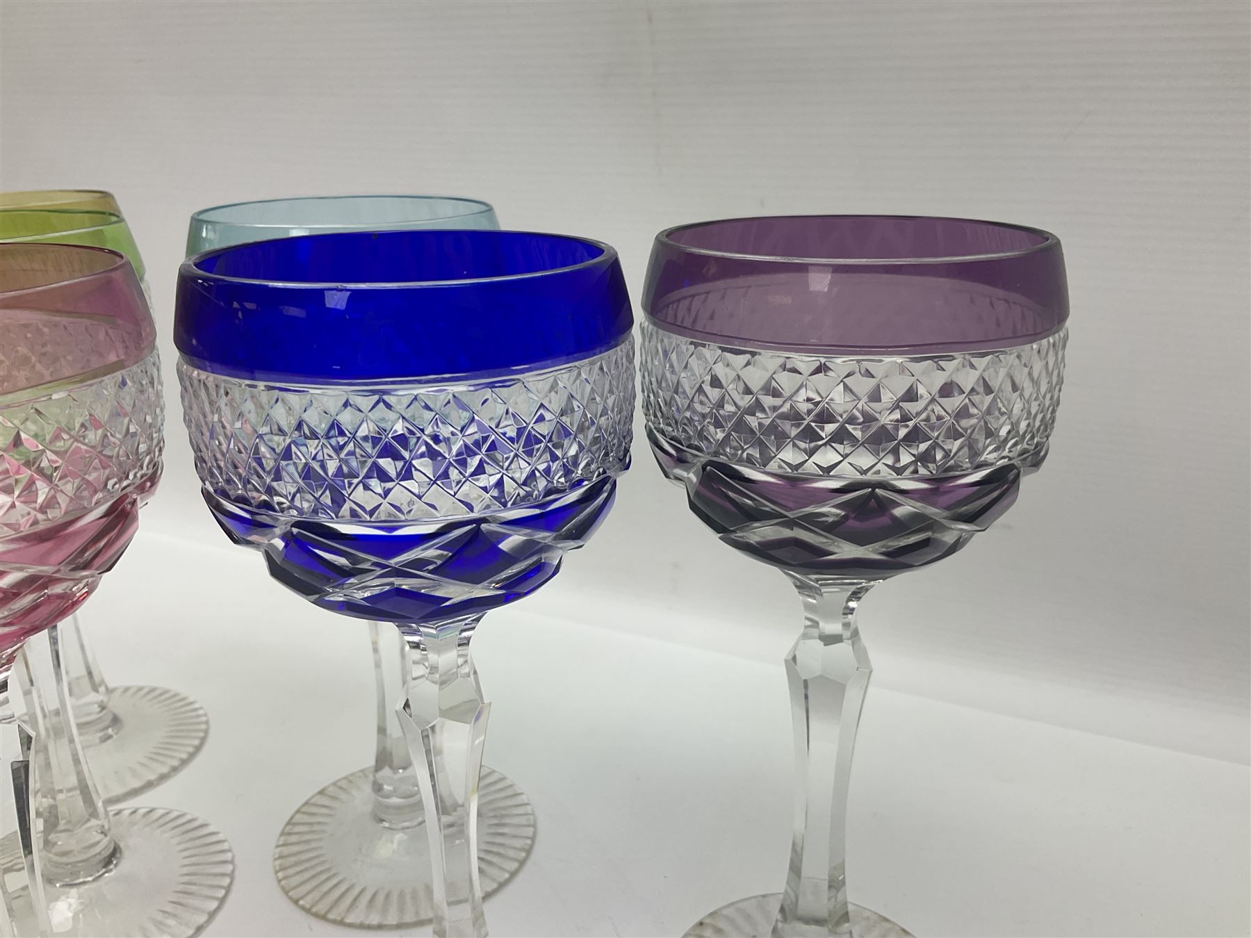 Set of six Harlequin coloured glass hock glasses, each with a band of hobnail decoration, upon faceted stems, H19.5cm