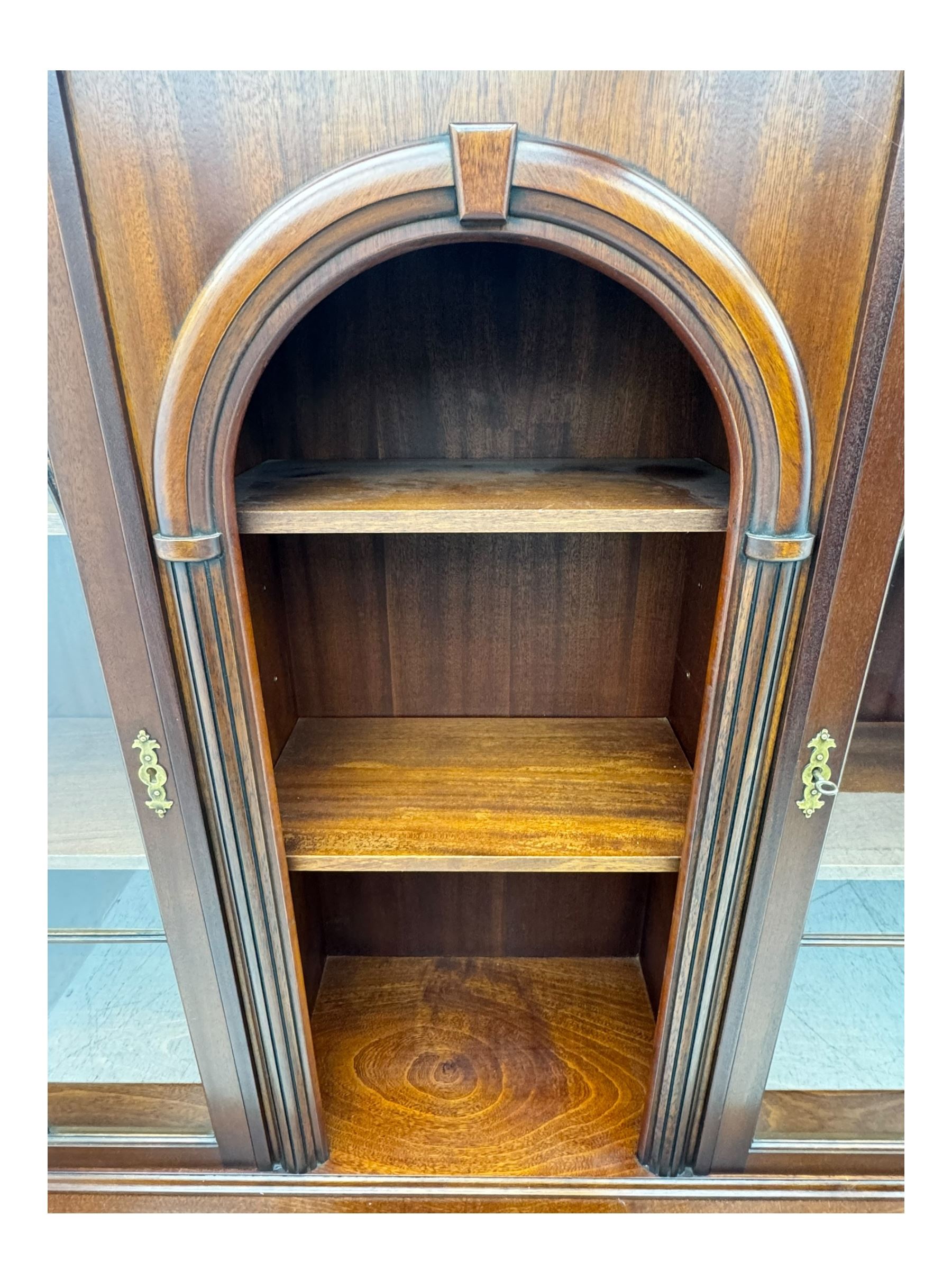 Georgian design mahogany bookcase on cupboard, projecting moulded and dentil cornice, two display cabinets enclosed by glazed doors above over three drawers and three cupboards, on bracket feet