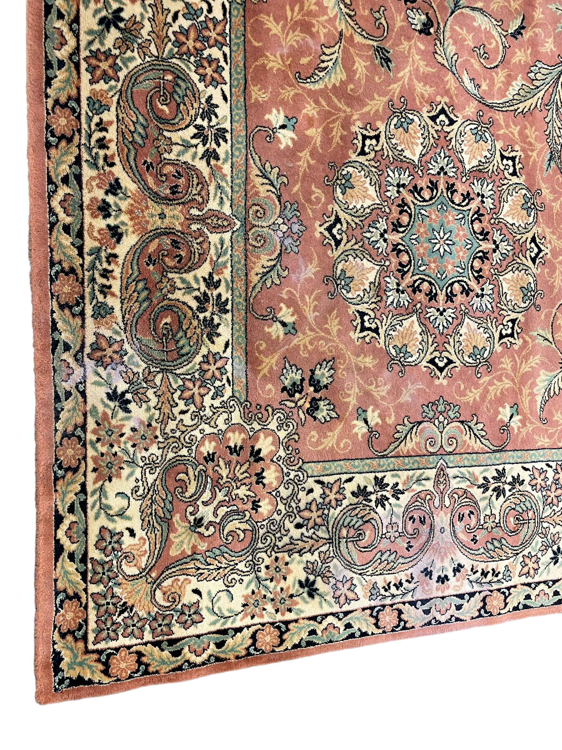 Persian design peach ground carpet, central floral medallion surrounded by scrolling foliage, decorated all over with stylised plant motifs, floral design repeating border