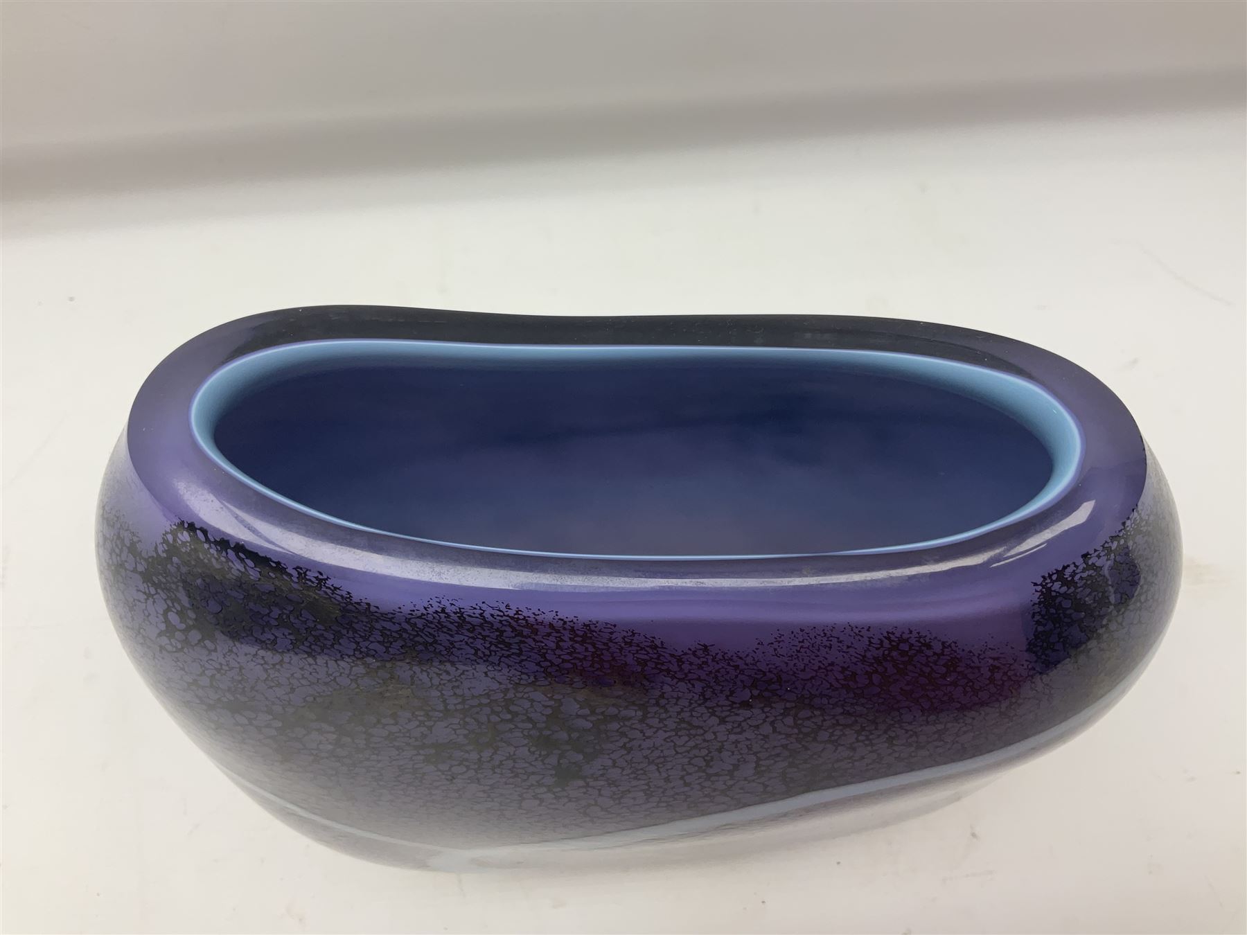 Stuart Akroyd glass vase, with blue ribbon decoration upon a mottled purple ground, engraved signature and sticker beneath, H25.5cm