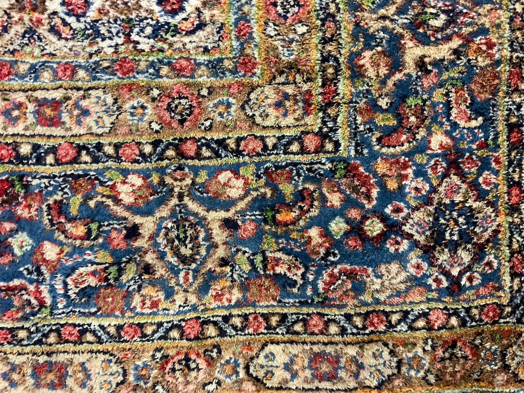 Persian indigo ground rug, the ivory field decorated with all-over flower heads, heavily guarded border with repeating stylised plant motifs