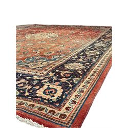 Persian Kashan crimson ground carpet, central shaped pale ground medallion surrounded by interlacing branches and stylised floral motifs, indigo main border with scrolling foliage design, within guard stripes 