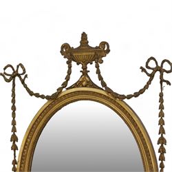 Late 19th century giltwood and gesso wall mirror, oval foliate moulded frame surmounted by urn and bell flower garlands, bevelled mirror plate 