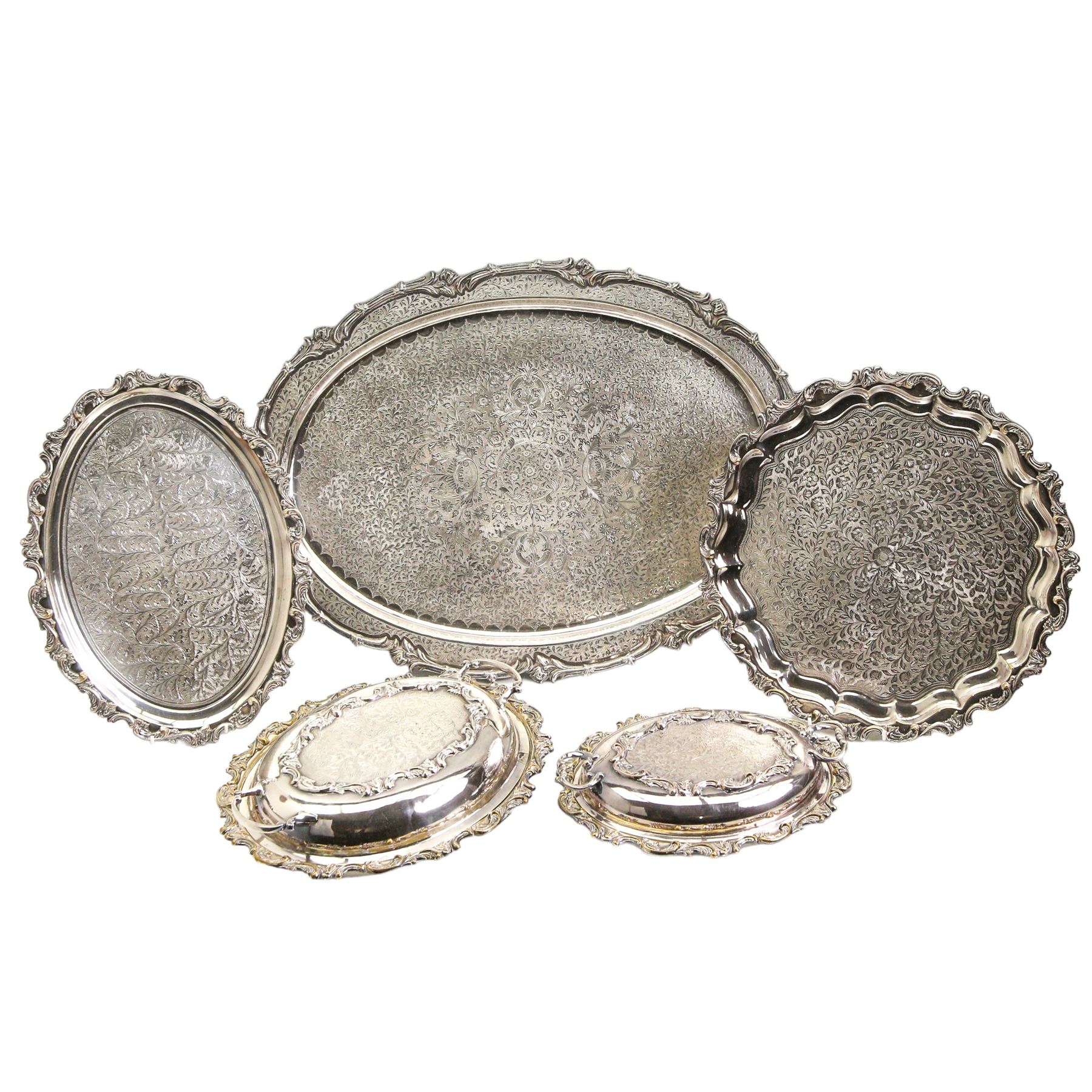 Continental silver-plated part dinner service comprising two graduated entree dishes & oval platters and salver, all having scroll cast borders and foliate engraved design, oval tray max L65cm 