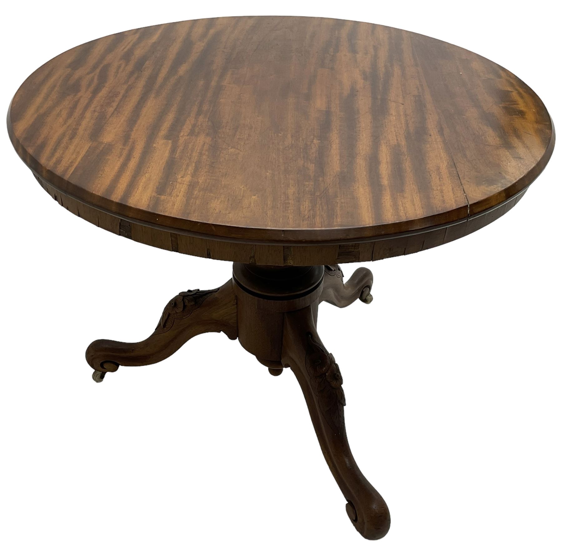 Victorian mahogany centre table, circular top on turned pedestal, on three flower head carved supports with scrolled terminals