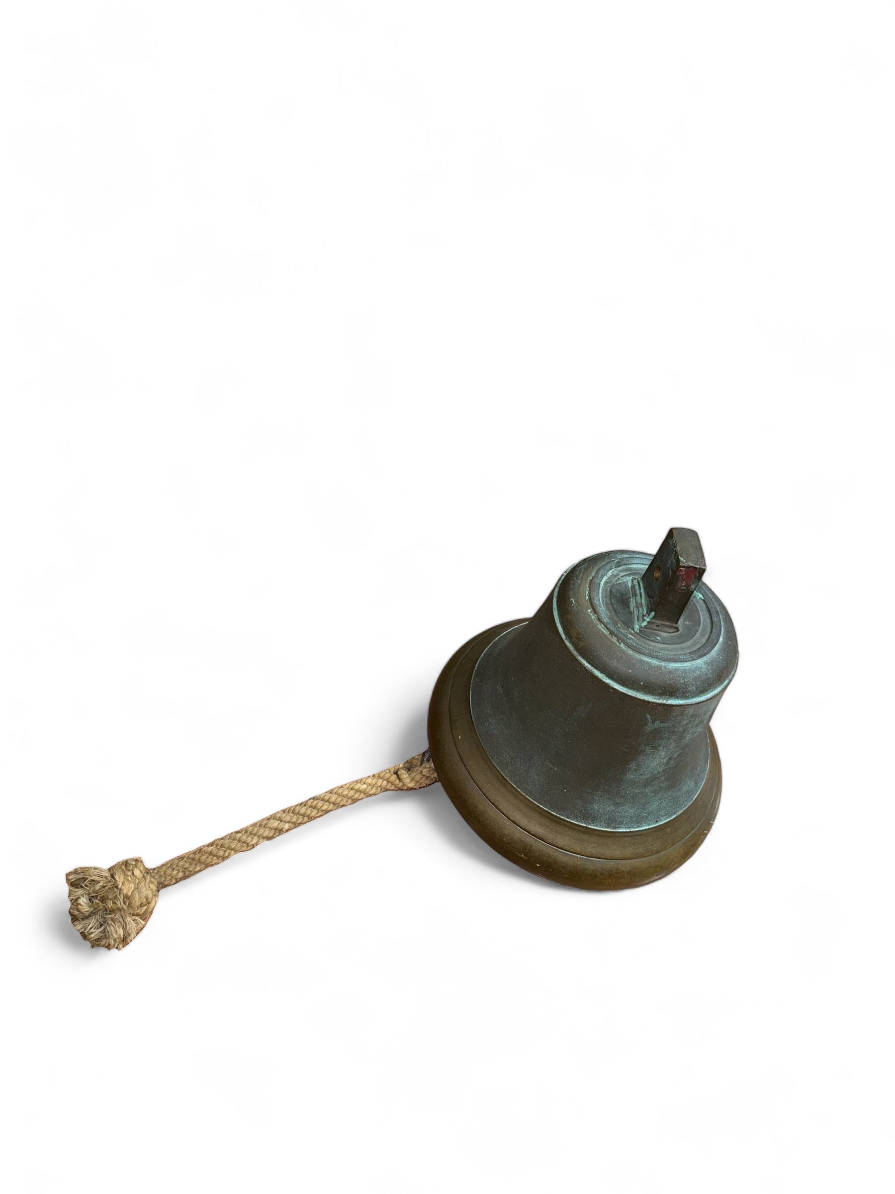 Late 19th century/early 20th century bell with rope pull, probably a fire bell, marked LCC G49 to canon, upon a black painted wrought iron wall mount, bell H29cm, mount H64cm