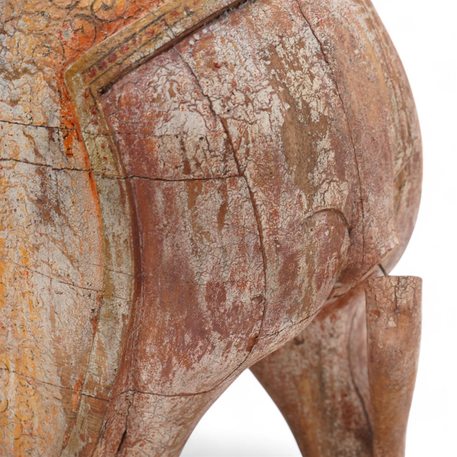 Early 20th century Indian hardwood and polychrome Elephant jardiniere stand, decorated with a headdress and vibrant saddle cloths, surmounted by an octagonal shaped saddle, with overall craquelure finish