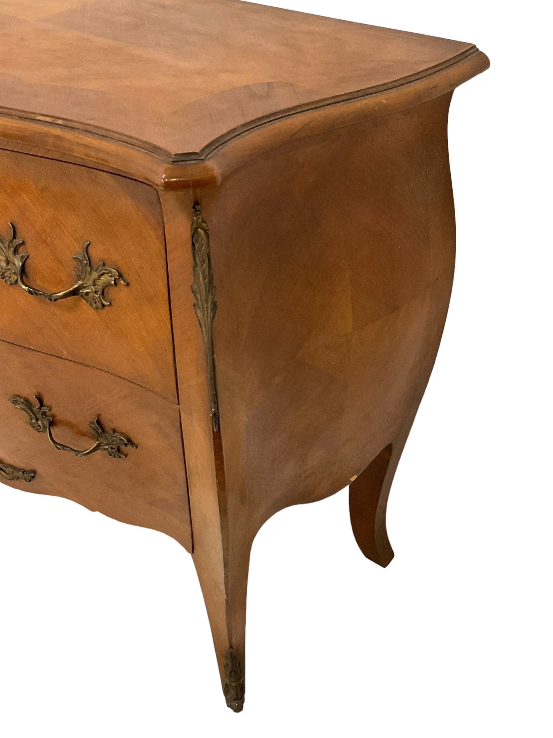 Late 20th century French design walnut bombe chest, shaped moulded top with quarter-matched veneers within crossbanding, fitted with two drawers with foliate cast metal handles and escutcheons, on tapering supports with ornate cast caps 