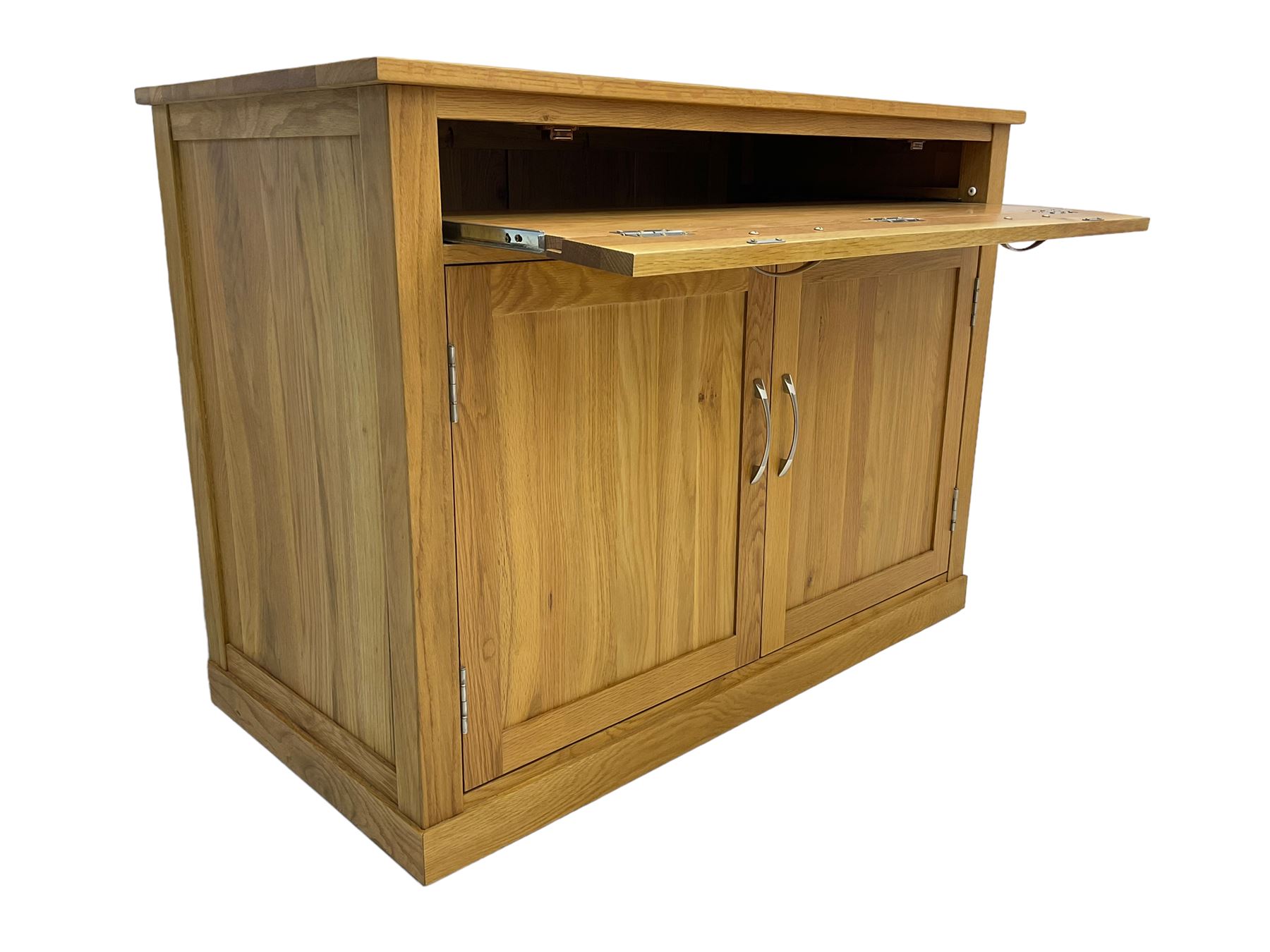 Contemporary light oak sideboard desk, rectangular top with full length drawer, hinged front panel revealing pull-out keyboard tray, over two panelled doors enclosing an assortment of shelves and compartments with cable management holes, on plinth base