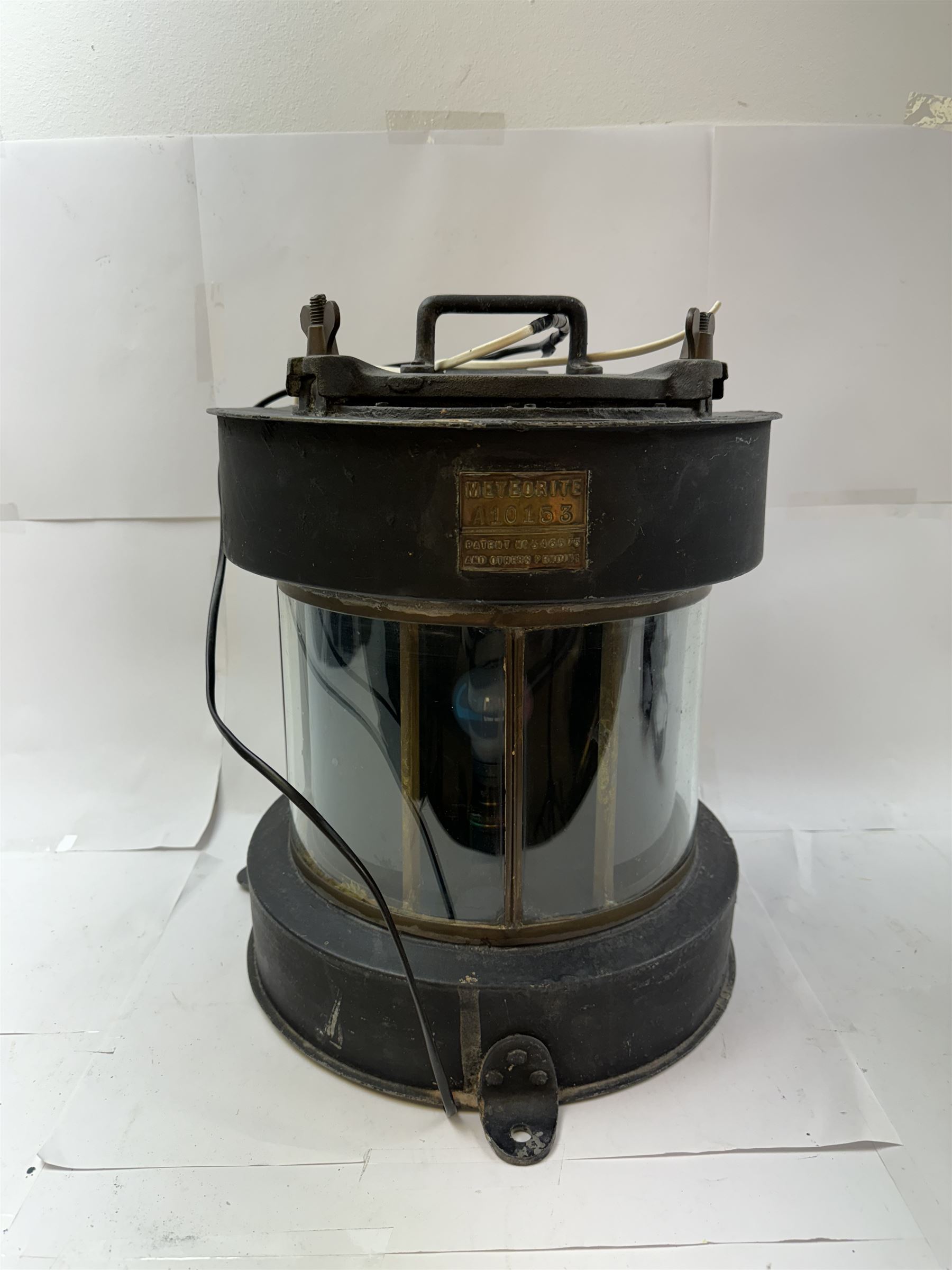 Meteorite ship's lamp converted to electricity, painted in black matte finish, with applied brass plaque inscribed 'Trawler' and a further plaque inscribed 'Meteorite A10153', H42cm