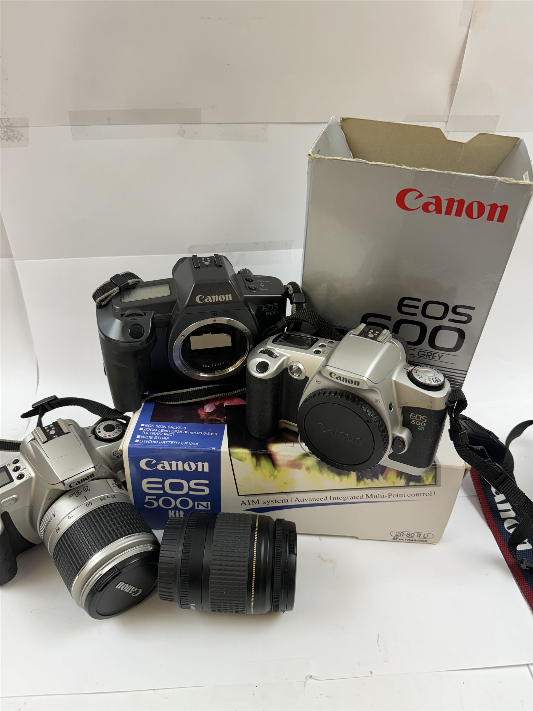 Three Canon EOS cameras, comprising EOS 500N Silver Kit, serial no. 9660130 with Canon EF 28-80mm 1:3.5-5.6 IV zoom lens, serial no. 9505171, EOS 300 with Canon EF 28-90mm 1:4-5.6 zoom lens, serial no. 5828460, and a Sigma 28-300mm 1:3.5-6.3 macro zoom lens, serial no. 1027931 and an EOS 600 camera body, serial no. 2651130, two boxed and one in carry case