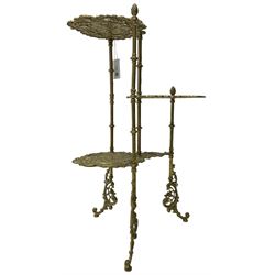 Cast gilt metal three-tier cake stand, each tier decorated with cast foliage scrolls and flower heads with a central bird motif, on turned and fluted supports with splayed C-scroll feet