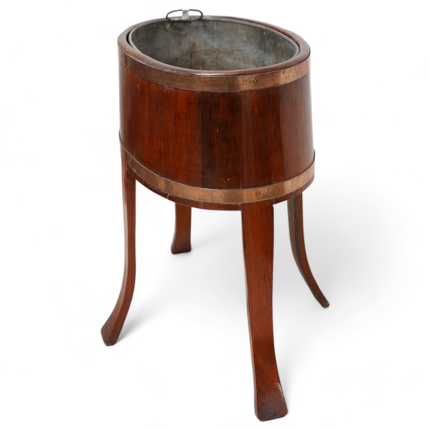 Late 19th century coopered mahogany wine cooler, oval form with metal liner and brass bands, on out splayed supports, bearing Sotherby's Country House sale label '2 May 1990' (Wherwell Priory)