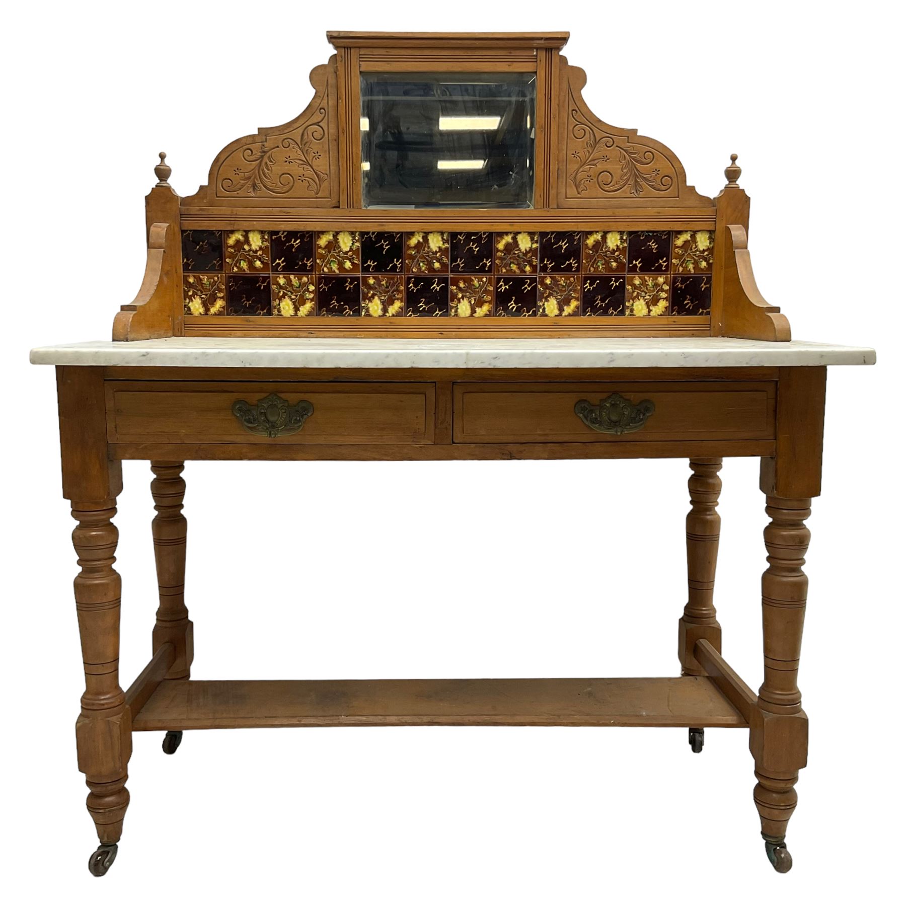 Late Victorian satin walnut washstand, raised bevelled mirror and tiled back carved with scrolled foliage, white marble rectangular top over two drawers, on collar turned supports joined by under-tier 