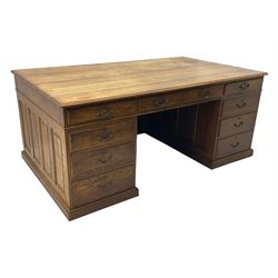 Large 20th century oak twin pedestal desk, moulded rectangular top over nine drawers, panelled pedestals, on moulded plinth base 