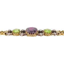 Early 20th century 15ct gold garnet, peridot and diamond, fancy link chain bracelet, the central cushion cut rhodolite garnet of approx 5.05 carat, with two cushion cut peridots set either side, spaced by three old cut diamonds, total diamond weight approx 0.35 carat, in fitted case by Garrard & Co